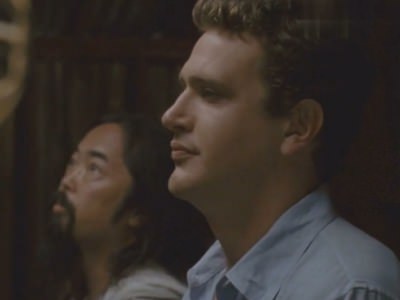 Парень смотрит на стену с голыми девушками